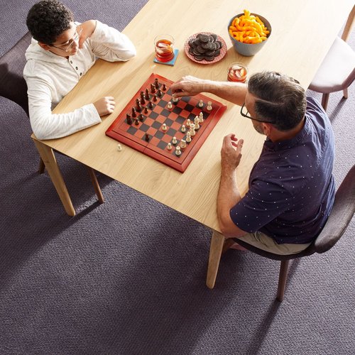 father and son playing chess while eating snaks from Deloreto Flooring Inc in Winter Park